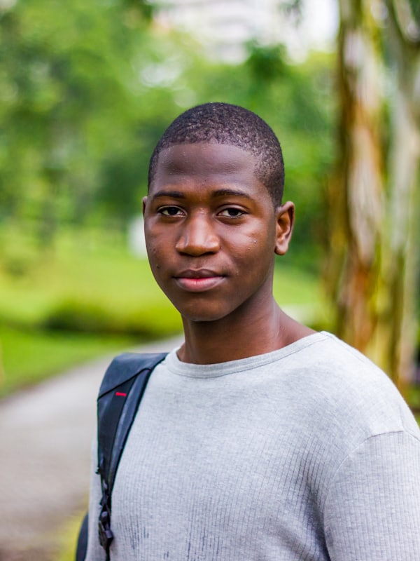 A teenage student with a backpack, standing outdoors